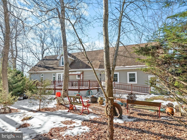 snow covered rear of property featuring a wooden deck