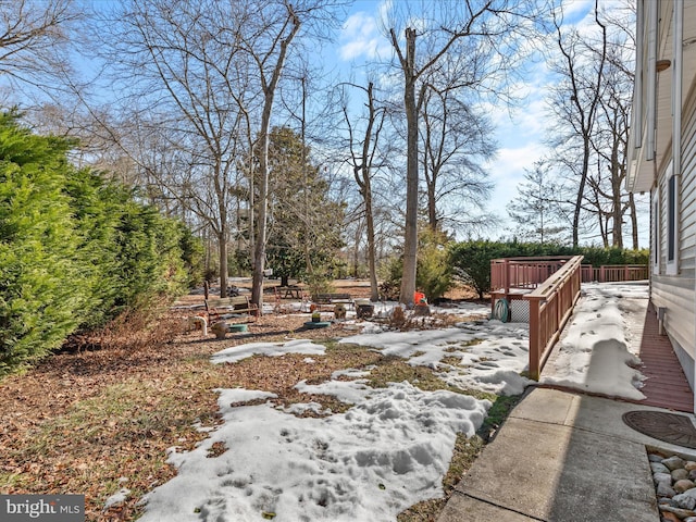 yard layered in snow featuring a wooden deck