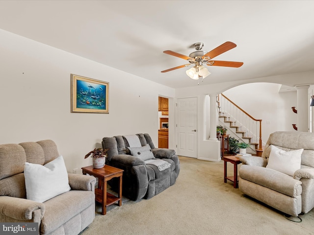 carpeted living room featuring ceiling fan and ornate columns