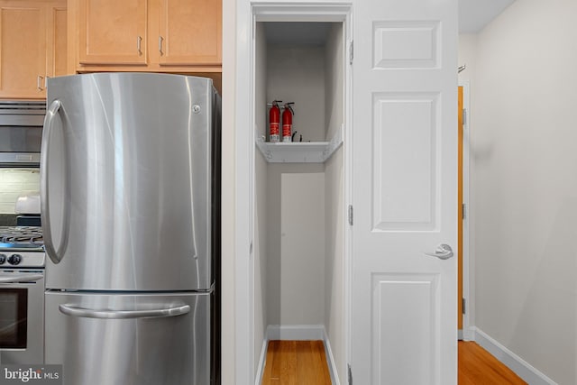 kitchen featuring tasteful backsplash, stainless steel appliances, light hardwood / wood-style flooring, and light brown cabinets