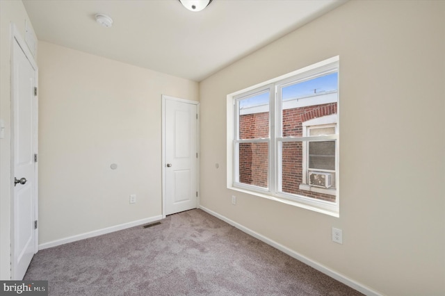 unfurnished bedroom with cooling unit and light colored carpet