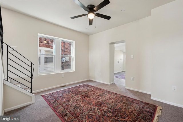 carpeted spare room featuring ceiling fan