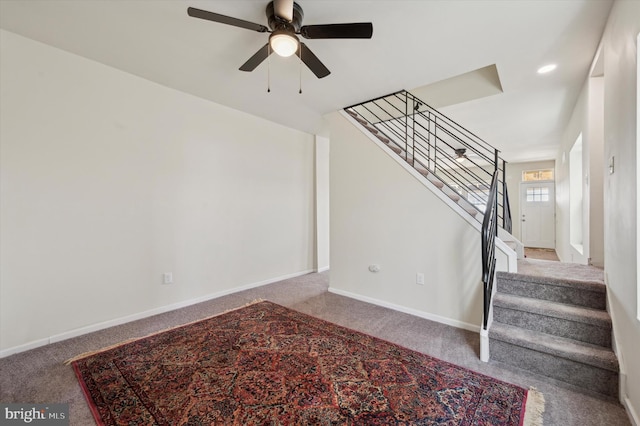 stairway featuring carpet floors and ceiling fan