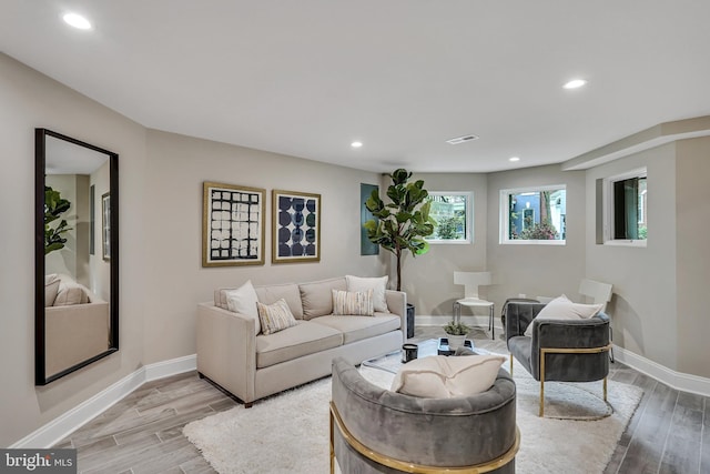 living room with light wood-style floors, baseboards, visible vents, and recessed lighting