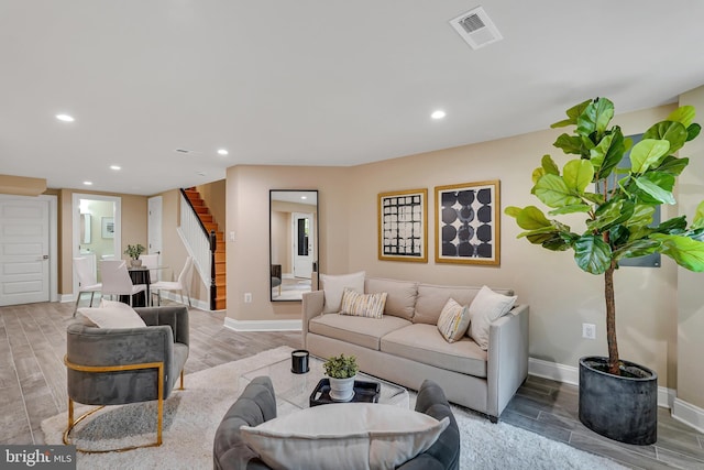 living area featuring light wood-style floors, visible vents, recessed lighting, stairway, and baseboards