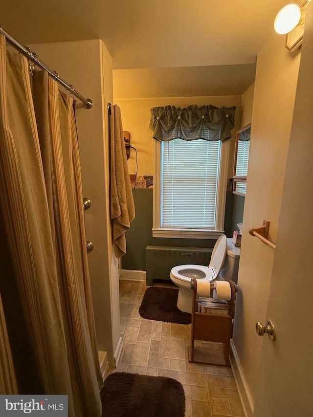 full bathroom with curtained shower and baseboards