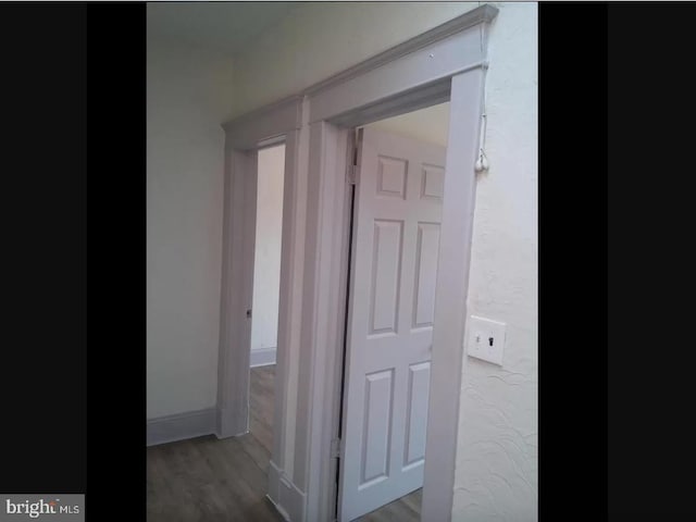 corridor with hardwood / wood-style flooring