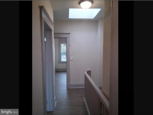 hallway featuring dark wood-type flooring and a skylight