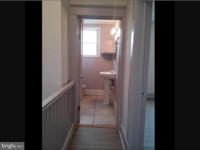 corridor with sink and light hardwood / wood-style flooring