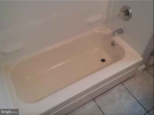 bathroom with tile patterned floors and shower / washtub combination