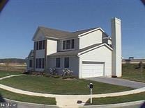 front of property with a garage and a front lawn