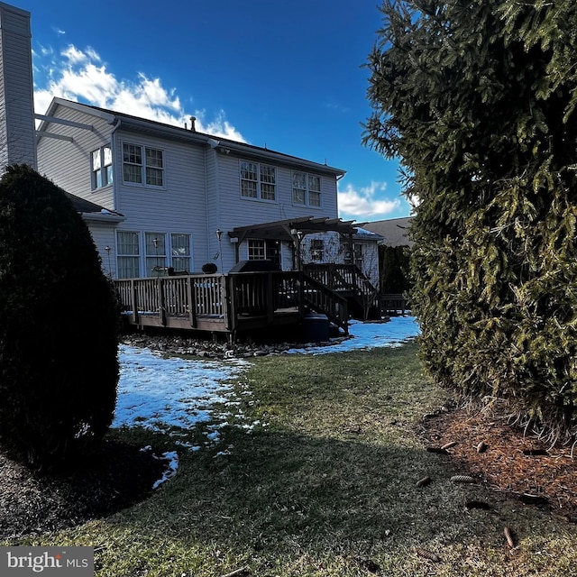 back of house featuring a wooden deck, a yard, and a pergola