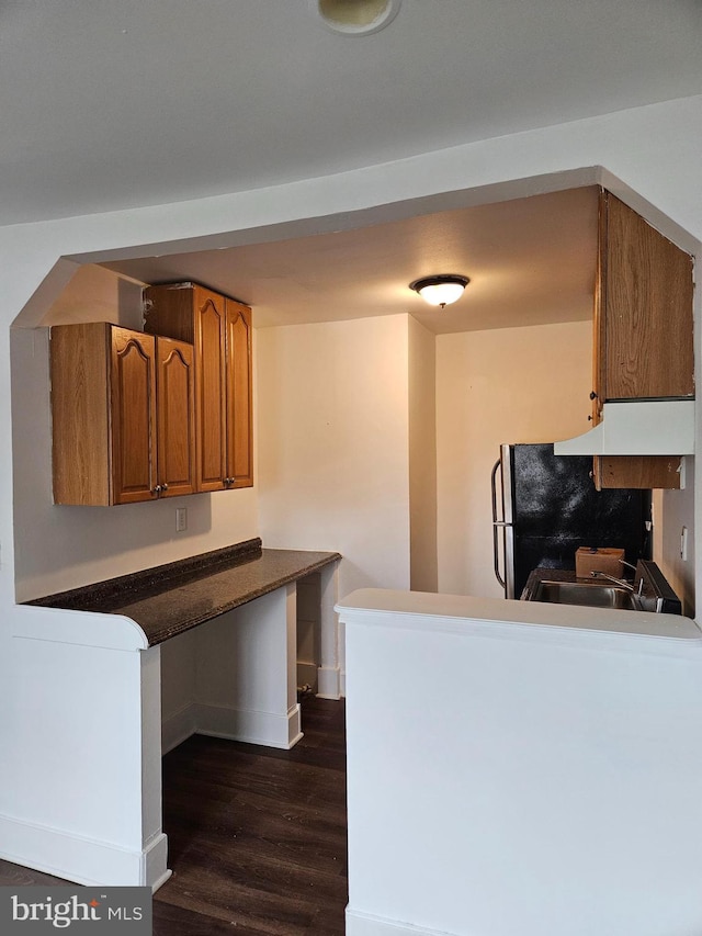 kitchen with sink, fridge, dark hardwood / wood-style floors, tasteful backsplash, and kitchen peninsula