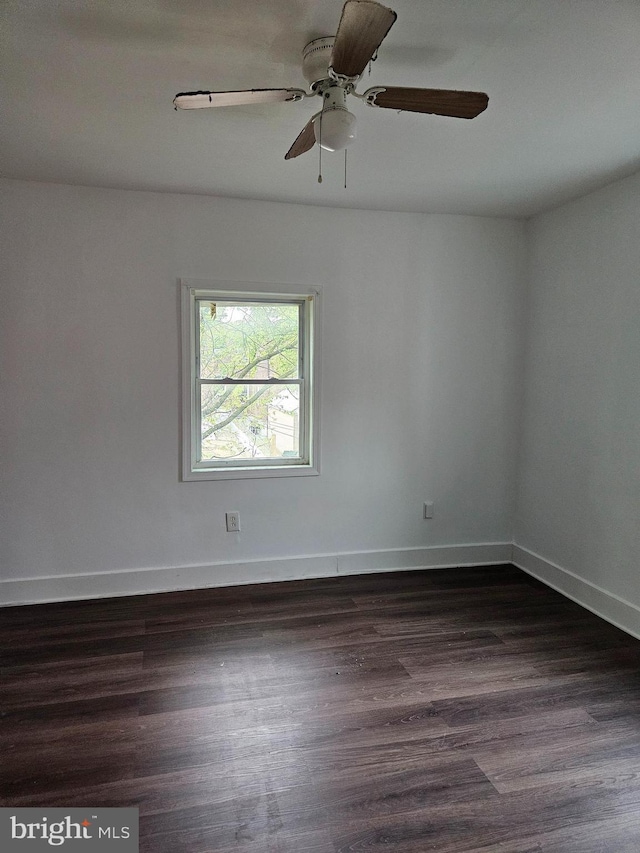 spare room with dark hardwood / wood-style flooring and ceiling fan