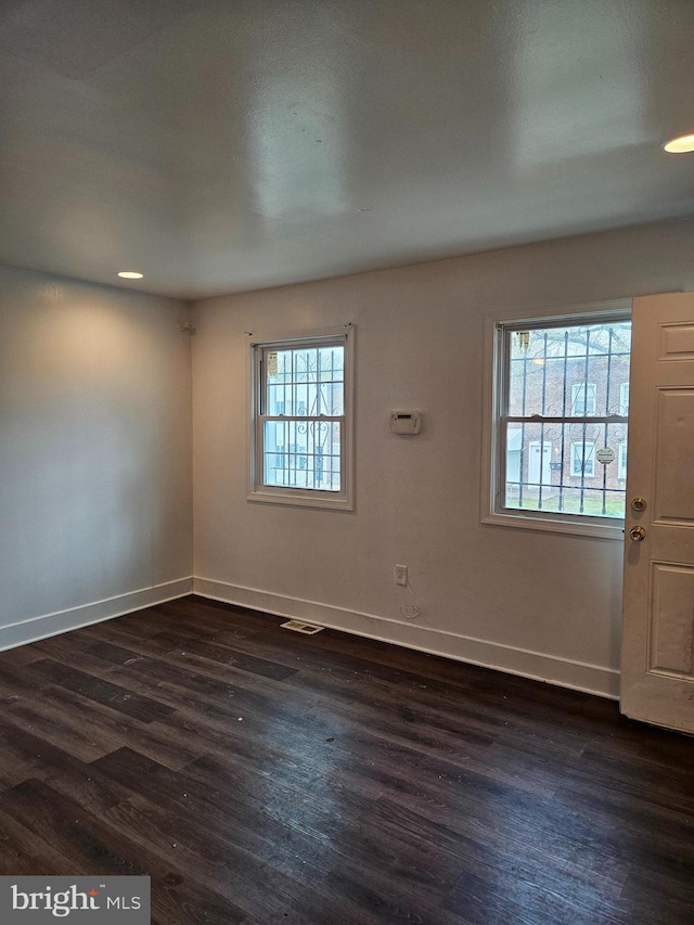 empty room with dark wood-type flooring