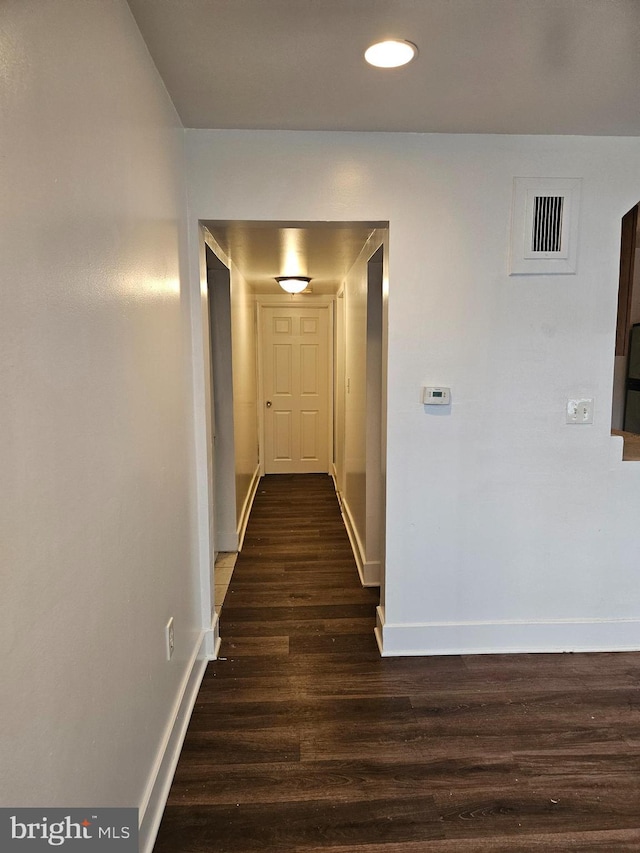 hallway with dark hardwood / wood-style flooring