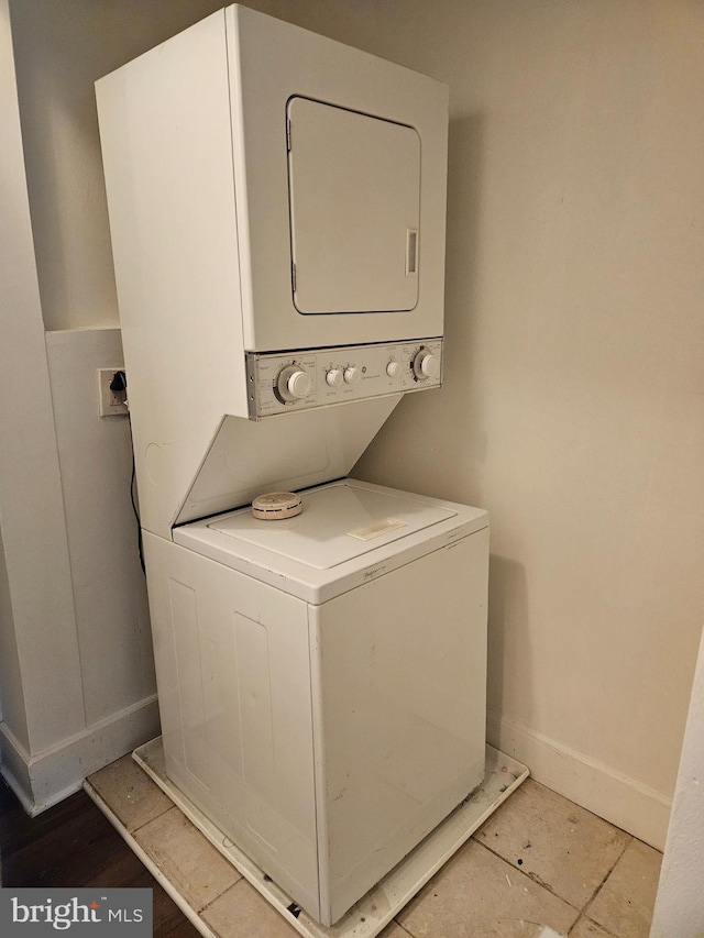 washroom featuring light tile patterned flooring and stacked washer / drying machine