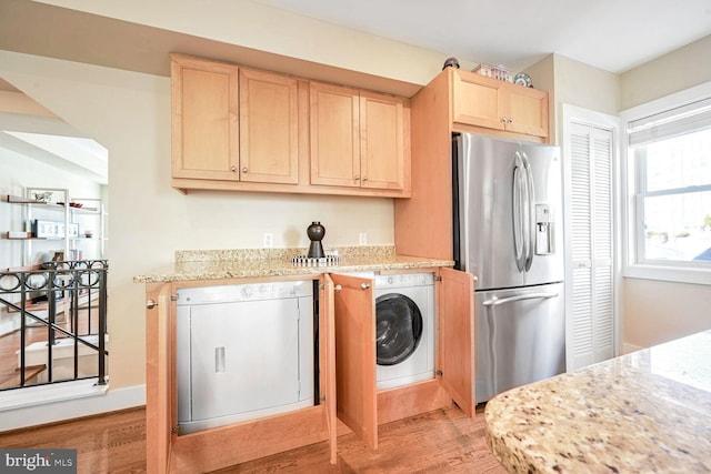 laundry room featuring washer / clothes dryer and light hardwood / wood-style flooring