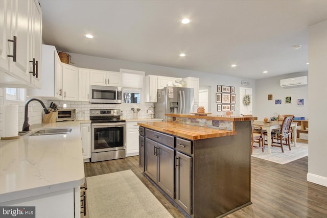480 Natural Dam Rd, Gettysburg, PA 17325 - kitchen with stainless steel appliances, butcher block countertops, a sink, a wall mounted air conditioner, and white cabinets