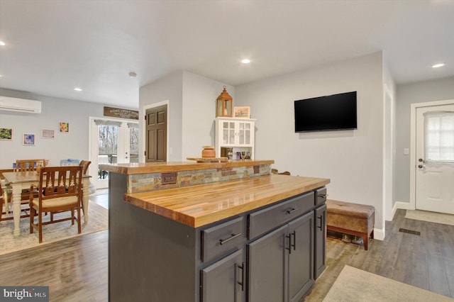 480 Natural Dam Rd, Gettysburg, PA 17325 - kitchen featuring wood counters, wood finished floors, an AC wall unit, recessed lighting, and baseboards