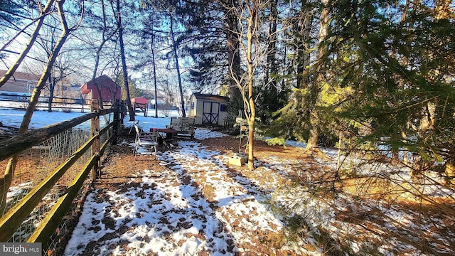 snowy yard with a storage shed