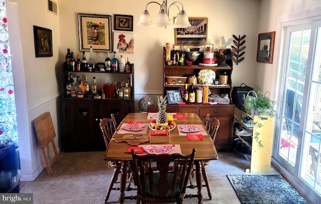 dining room with light tile patterned floors and a chandelier