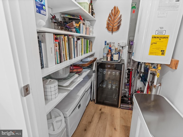 interior space with water heater, hardwood / wood-style flooring, and beverage cooler