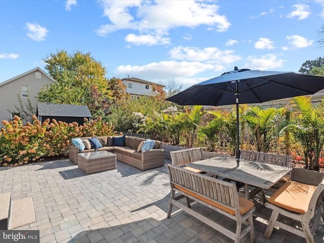 view of patio with an outdoor living space and a storage unit