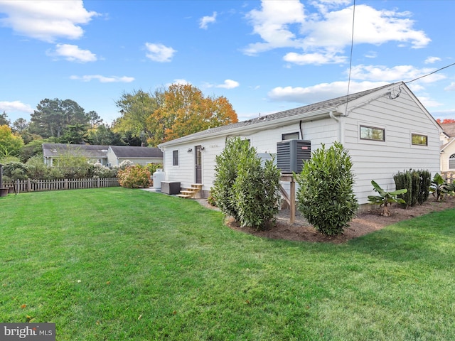 back of house featuring a yard and central air condition unit