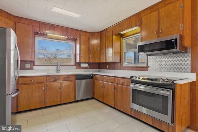 kitchen with stainless steel appliances, sink, wooden walls, and decorative backsplash