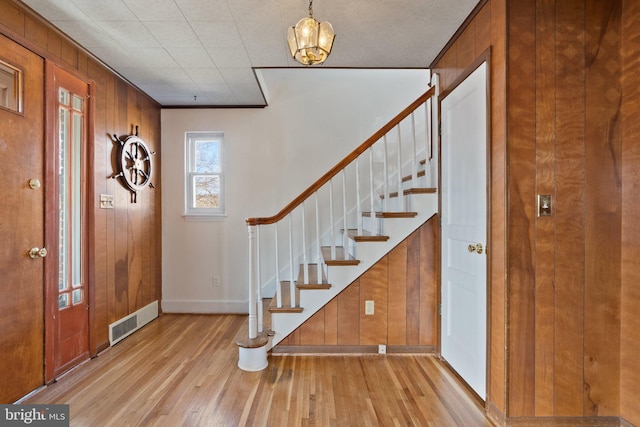 foyer featuring wooden walls and light hardwood / wood-style floors