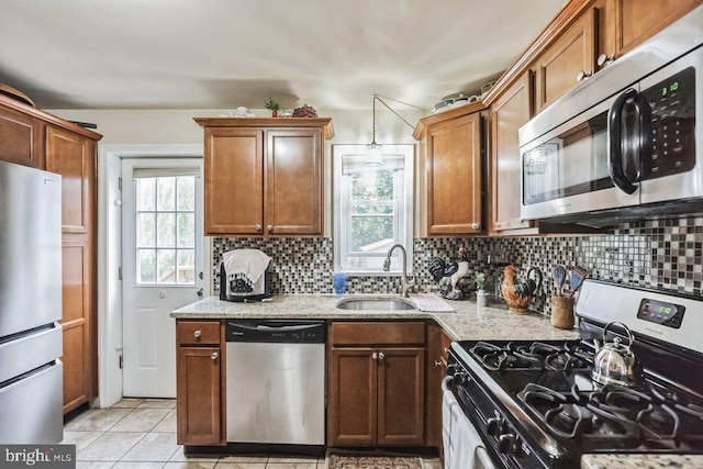 kitchen with a healthy amount of sunlight, appliances with stainless steel finishes, sink, and decorative backsplash