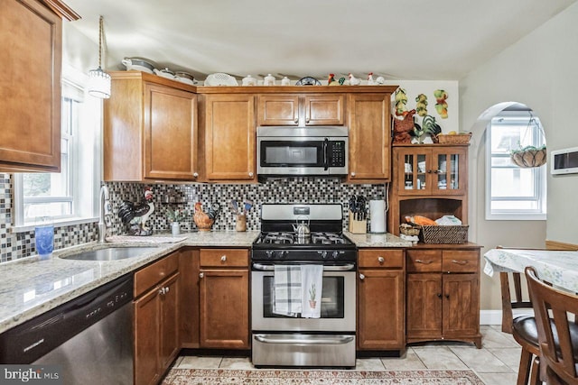 kitchen with sink, stainless steel appliances, a healthy amount of sunlight, and light tile patterned flooring