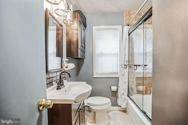 full bathroom with vanity, bath / shower combo with glass door, and toilet