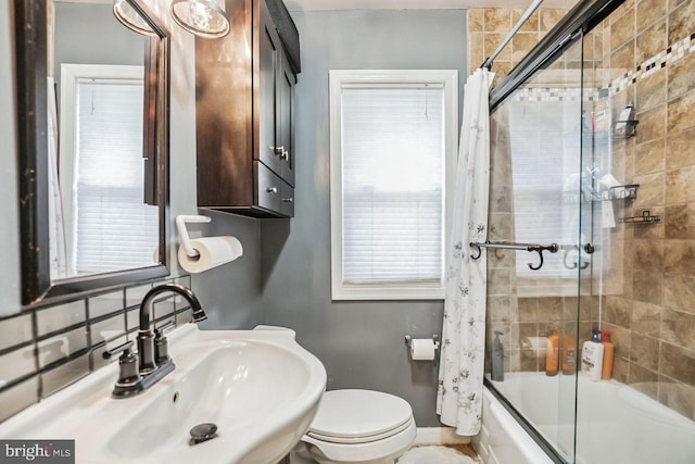 full bathroom featuring shower / tub combo with curtain, sink, a healthy amount of sunlight, and toilet