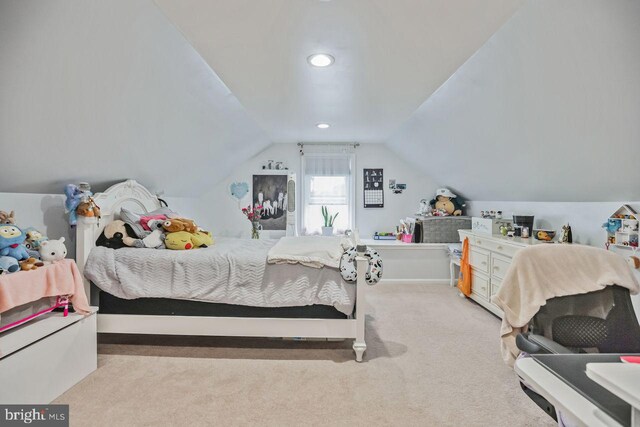 bedroom with vaulted ceiling and light colored carpet