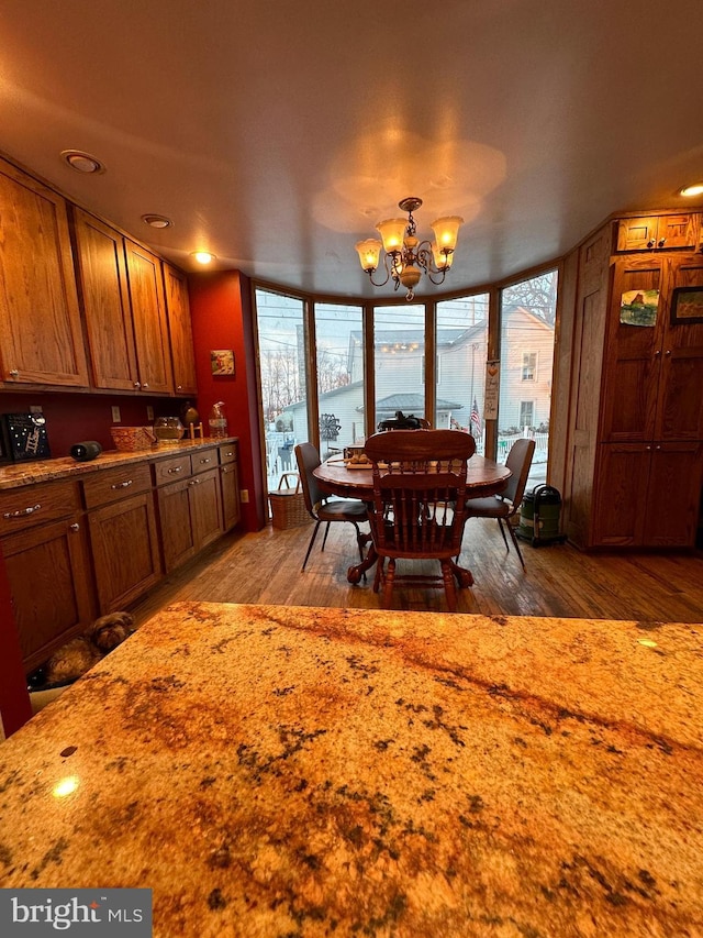 dining room with hardwood / wood-style flooring, a water view, and a chandelier