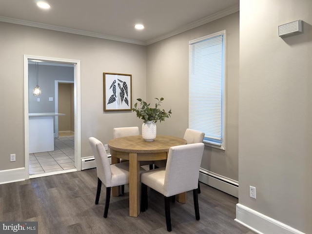 dining area featuring crown molding, a baseboard radiator, and wood-type flooring