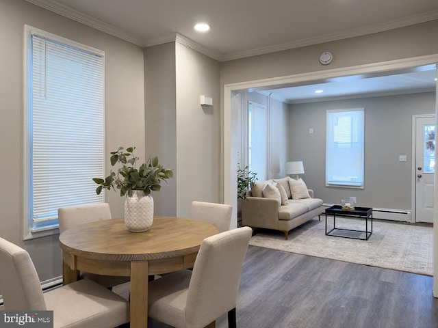 dining space with hardwood / wood-style flooring, ornamental molding, and a healthy amount of sunlight