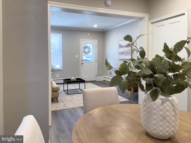 dining area with hardwood / wood-style flooring, ornamental molding, and baseboard heating