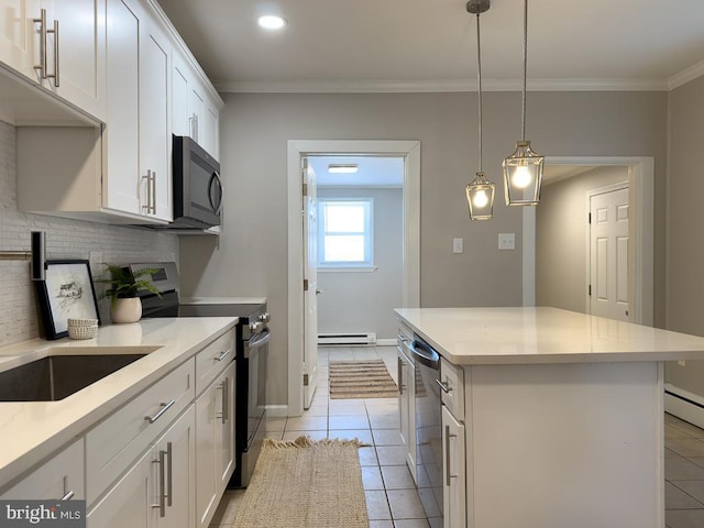 kitchen featuring decorative light fixtures, a baseboard radiator, a kitchen island, stainless steel appliances, and white cabinets