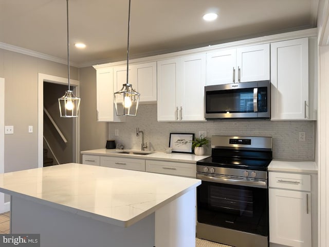 kitchen featuring sink, white cabinetry, decorative light fixtures, appliances with stainless steel finishes, and a kitchen island