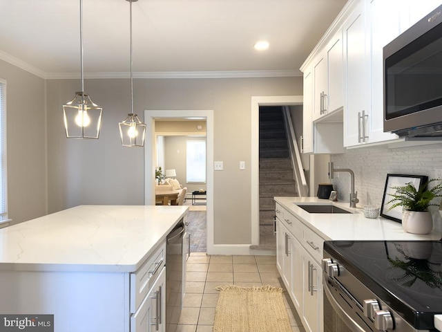 kitchen featuring a kitchen island, white cabinetry, appliances with stainless steel finishes, and sink