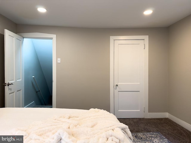 bedroom featuring dark carpet and a closet