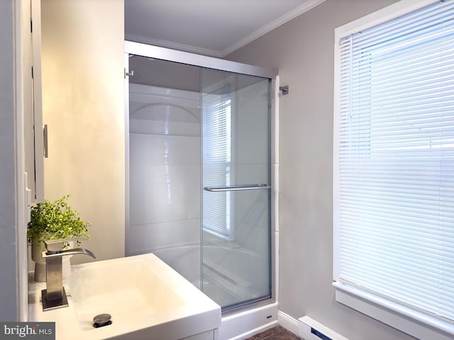 bathroom featuring a wealth of natural light, sink, ornamental molding, an enclosed shower, and baseboard heating