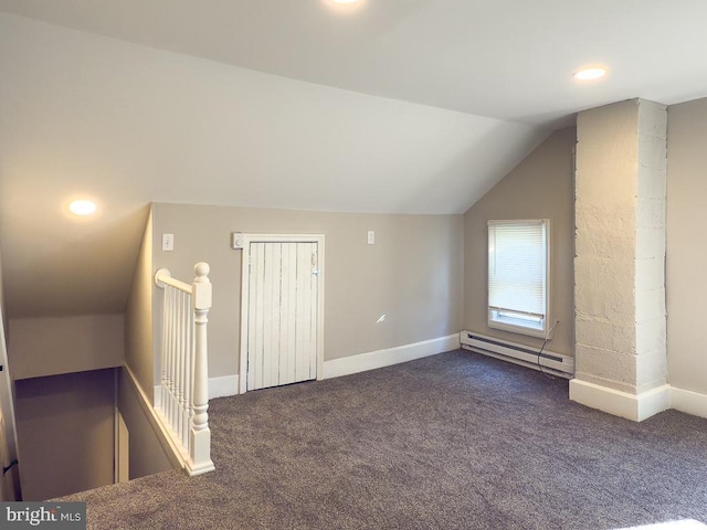 additional living space with lofted ceiling, dark carpet, and a baseboard heating unit