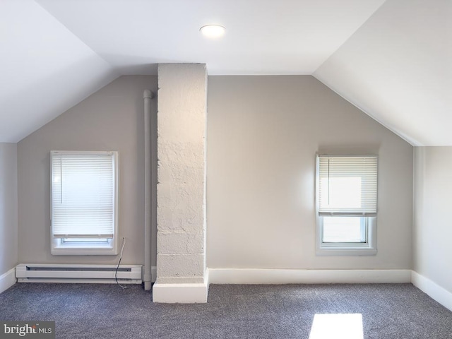 additional living space featuring a baseboard radiator, vaulted ceiling, and dark colored carpet