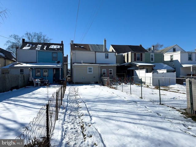 view of snow covered rear of property