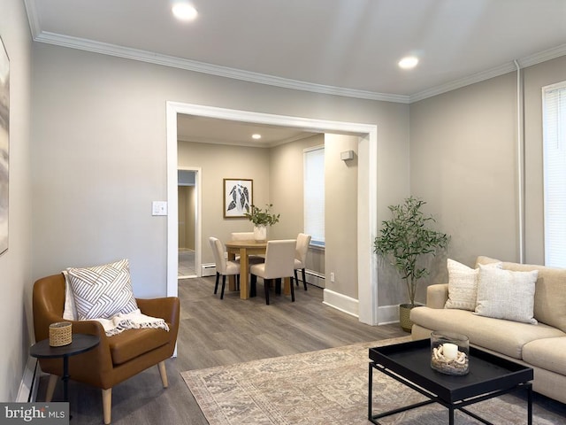 living room featuring baseboard heating, ornamental molding, and hardwood / wood-style floors