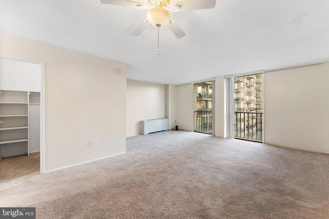 carpeted empty room featuring ceiling fan and a textured ceiling